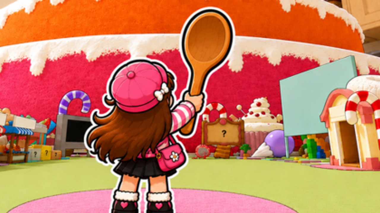 Cake Mountain player in a pink hat raising a wooden spoon in front of the rainbow cake mountain